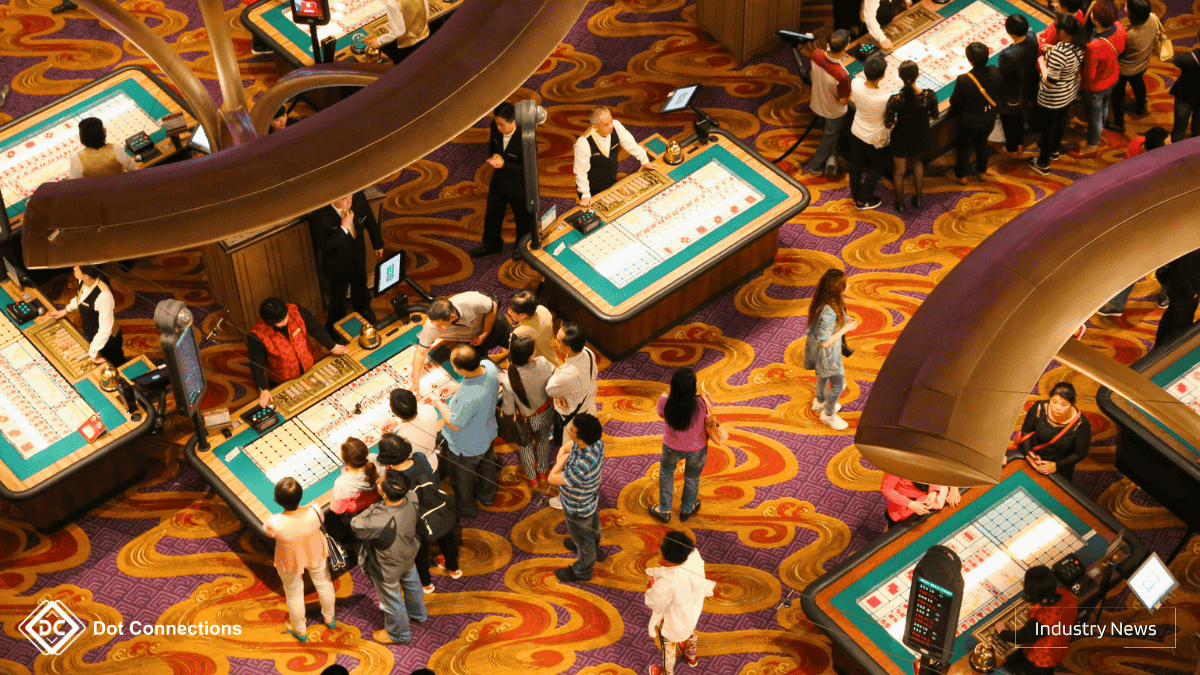 Crowd gathered around casino tables in Macau with dealers managing games.