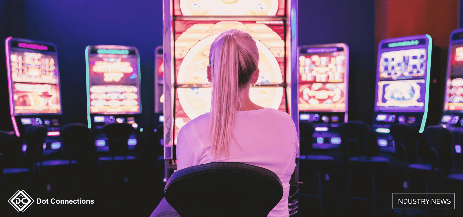 A woman sitting in front of brightly lit slot machines in a casino.