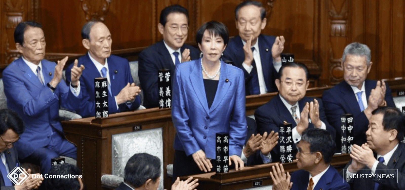 The Japan's new Prime Minister Sanae Takaichi stands in parliament while other lawmakers applaud.