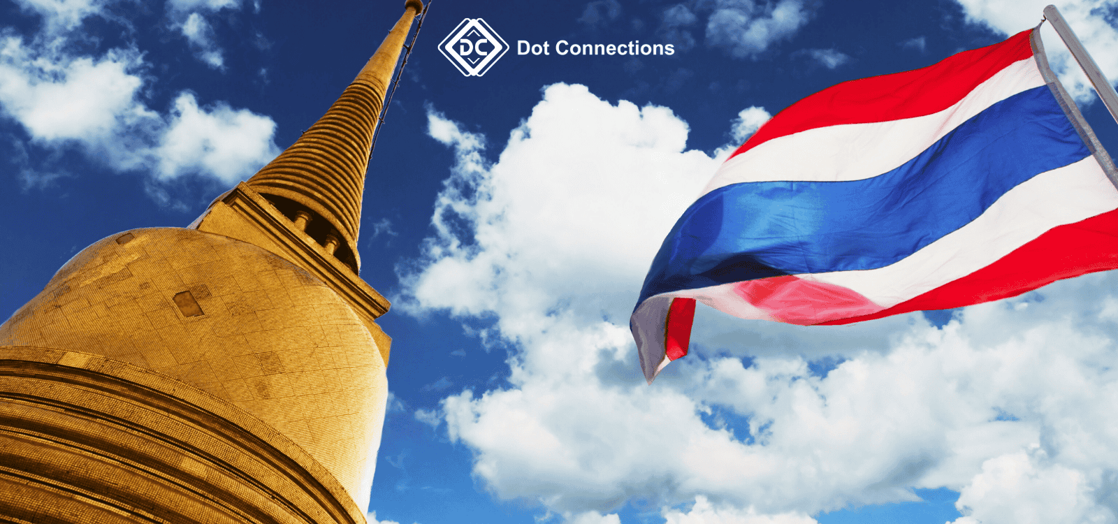 Thai flag waving beside a golden chedi under blue sky
