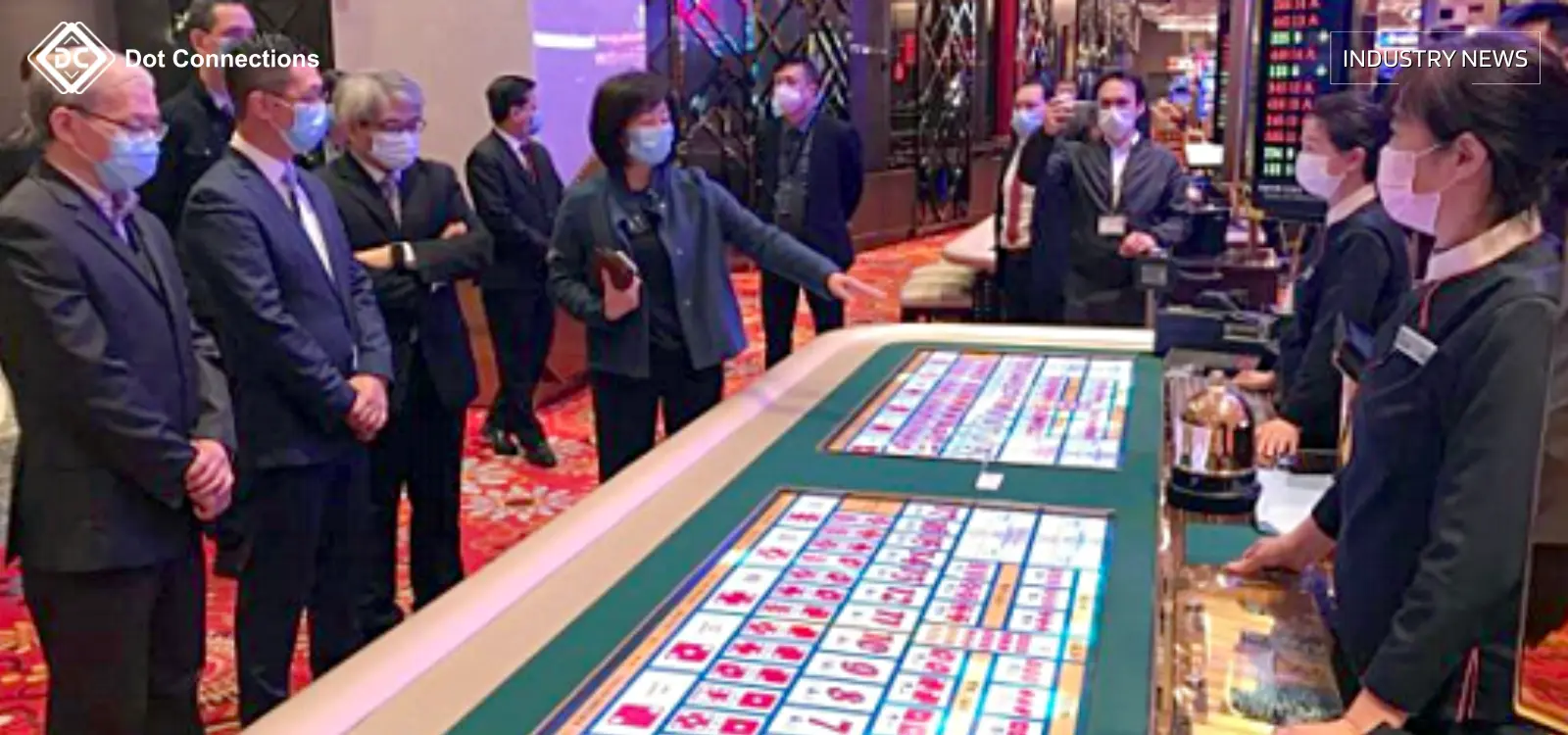 People discussing at a casino table in Macau — industry delegation observation.